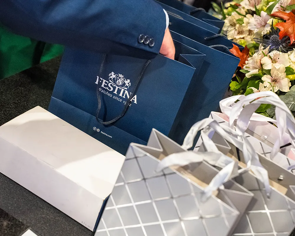 Gift bags and flowers on an event reception desk