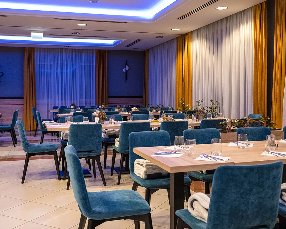Event hall set with blue chairs and white tables
