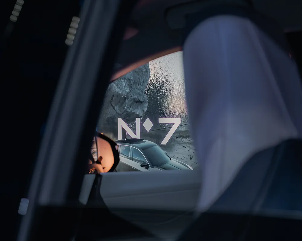 Detail through a car window, with a poster beyond