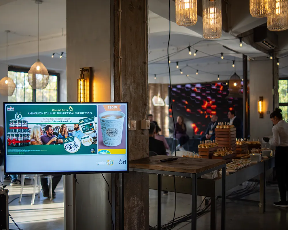 Event venue with a display screen and a buffet table at a corporate event