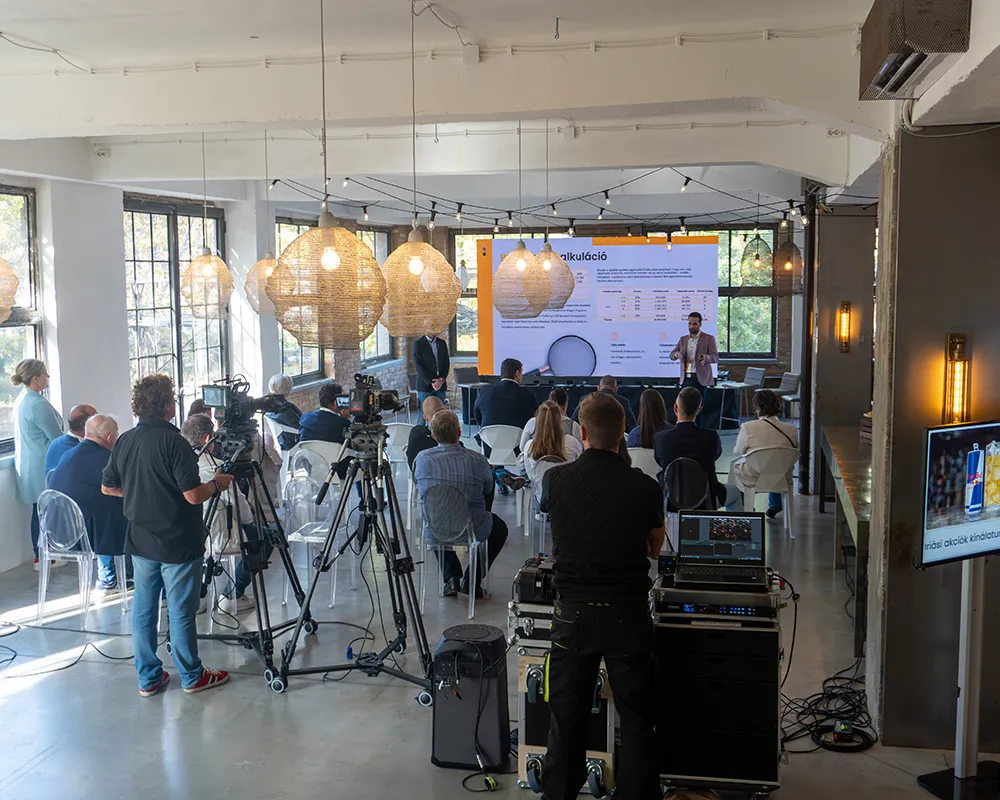 Industry talk with an audience and cameras in a bright event hall