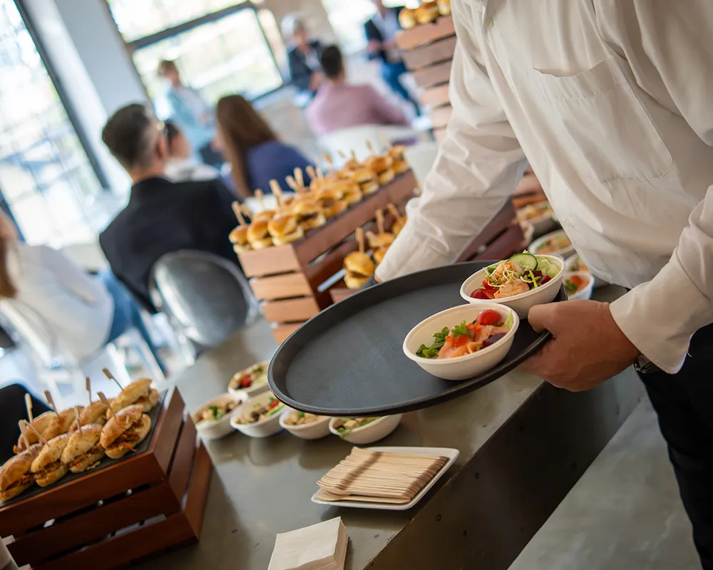 Server presenting dishes at the catering counter