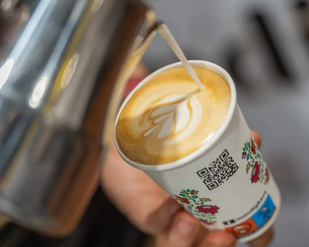 Close-up of latte art coffee in a paper cup